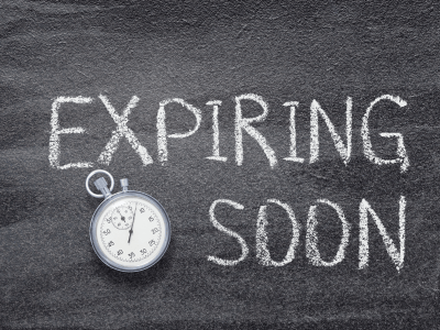 Stopwatch beside the words "Expiring Soon" written in chalk, symbolizing outdated technology approaching end-of-service.