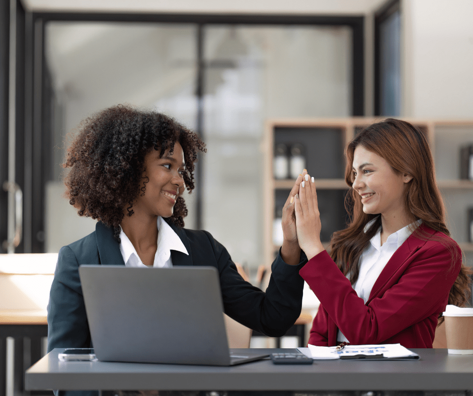 Two happy employees high fiving after getting a job done